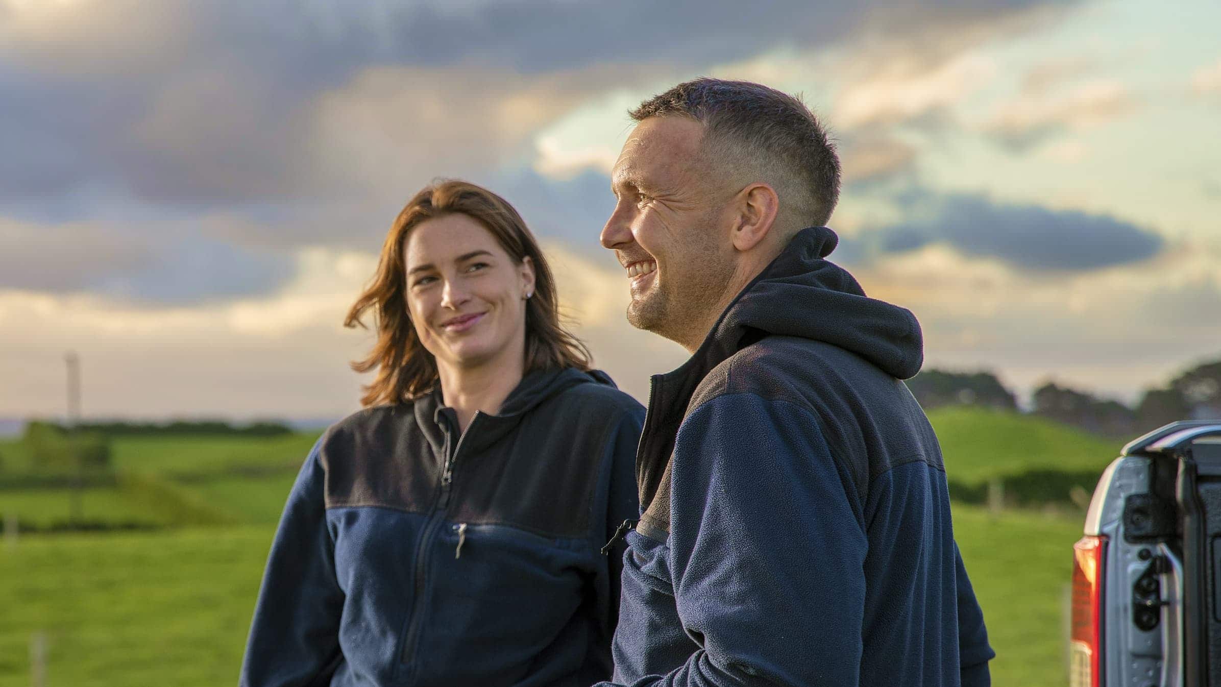 Donovan Croot and Sophie Cookson of Clovalley Farms laugh together on a farm.